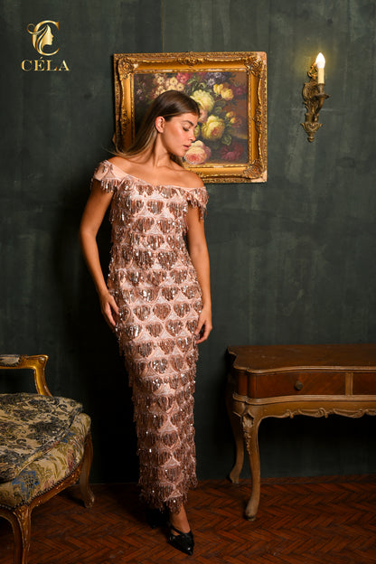 Woman in a patterned dress standing in an elegant room with a painting on the wall.