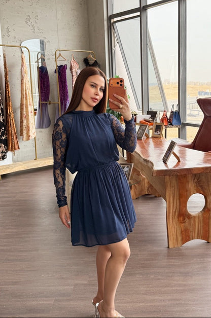 Woman taking a mirror selfie in a stylish room with large windows and wooden furniture.