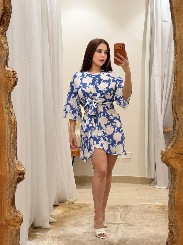 Woman taking a mirror selfie wearing a blue and white floral dress.