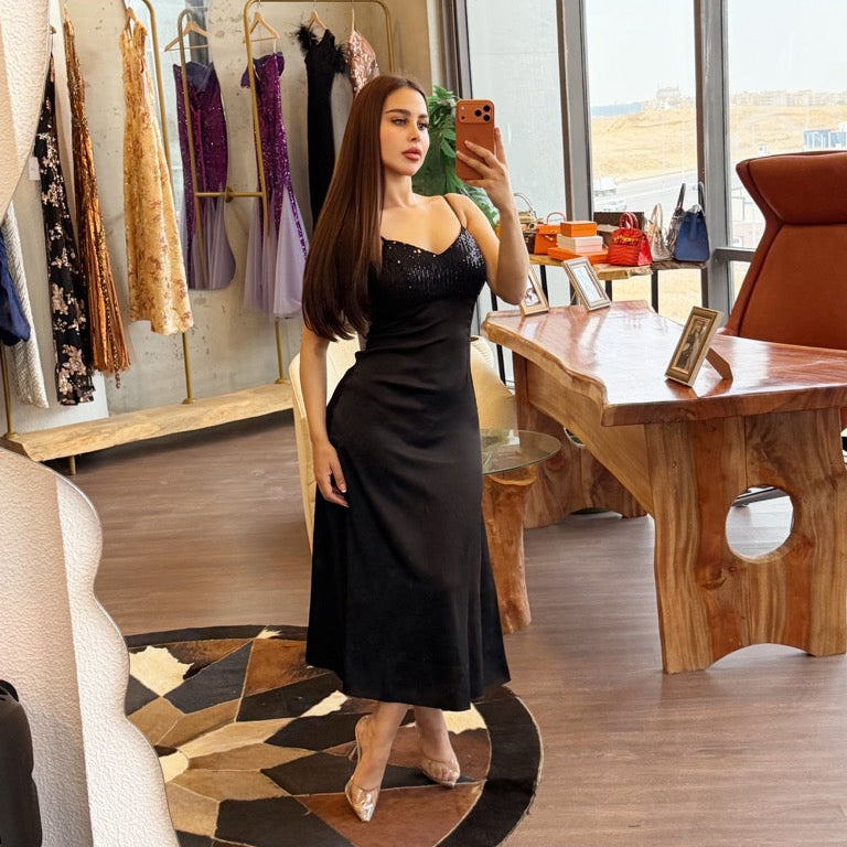 Woman taking a mirror selfie in a stylish room with decor elements.