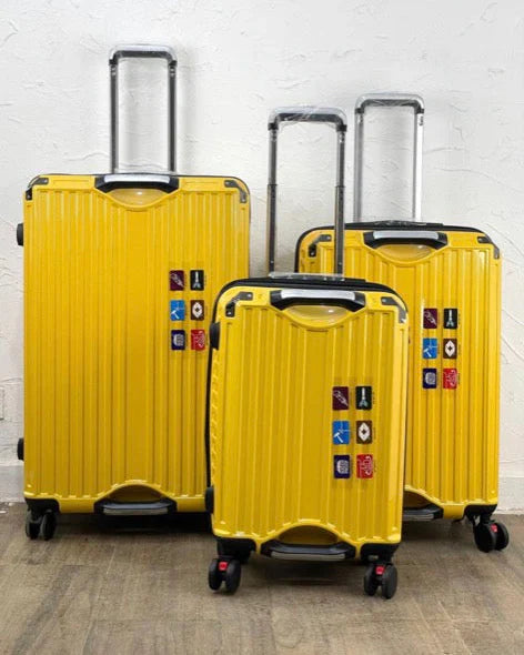 Three yellow suitcases with multiple locks on a wooden floor.