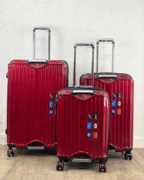 Set of red suitcases with visible brand logos on a light gray background