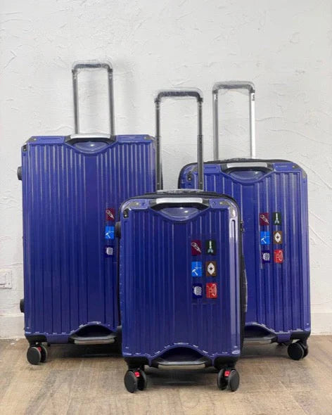 Three blue suitcases of different sizes on a light wooden floor.
